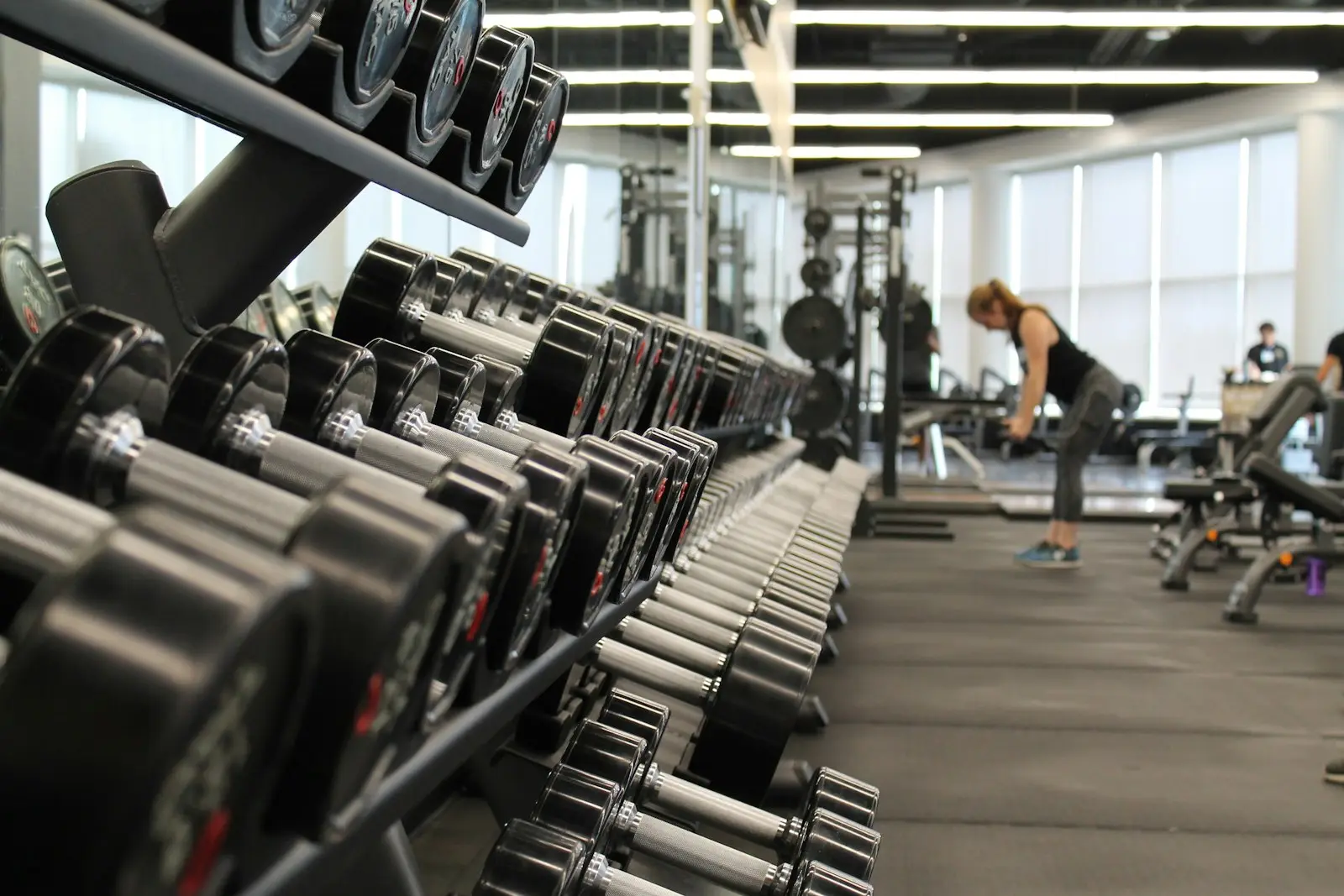 Salão de musculação do Vértice com rack de halteres em primeiro plano